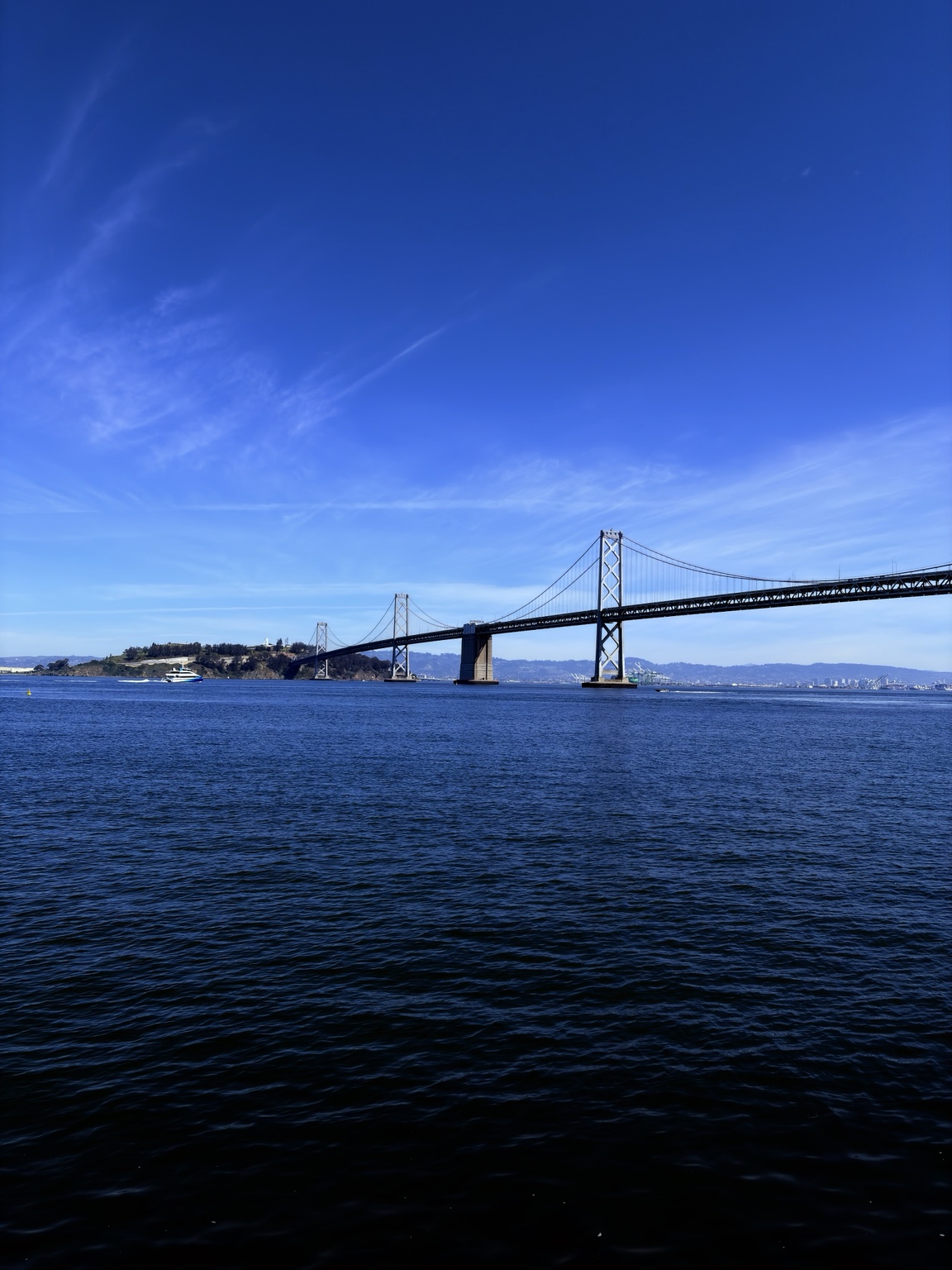 The Bay Bridge stretching across blue San Francisco Bay